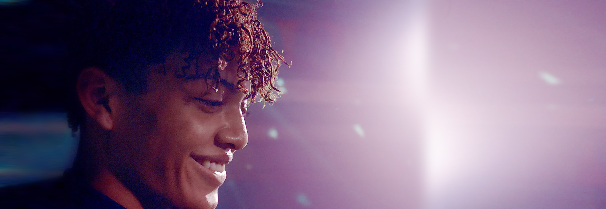 A young person looking down and smiling on a web-page about Kids Help Phone Foundation