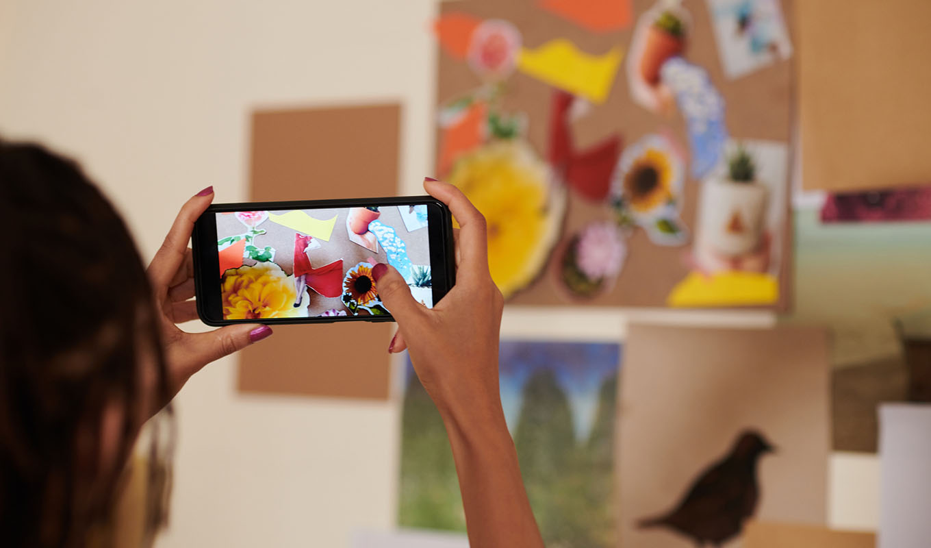 Community creator using a smartphone to take a photo of artwork